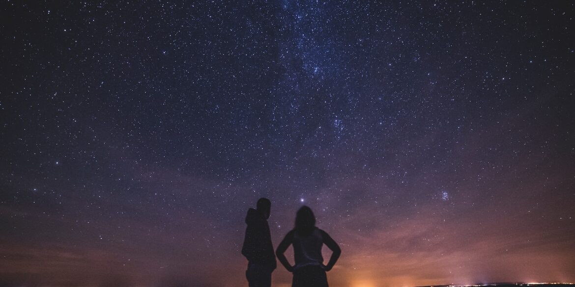 silhouette of people under milky way