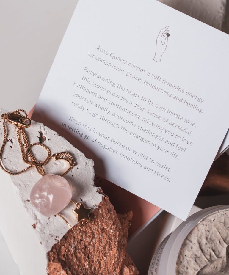 Softly lit flat lay with open vintage book, white rose, and cozy textures — ideal for spiritual reflection, astrology writing, manifesting rituals, and feminine journaling.