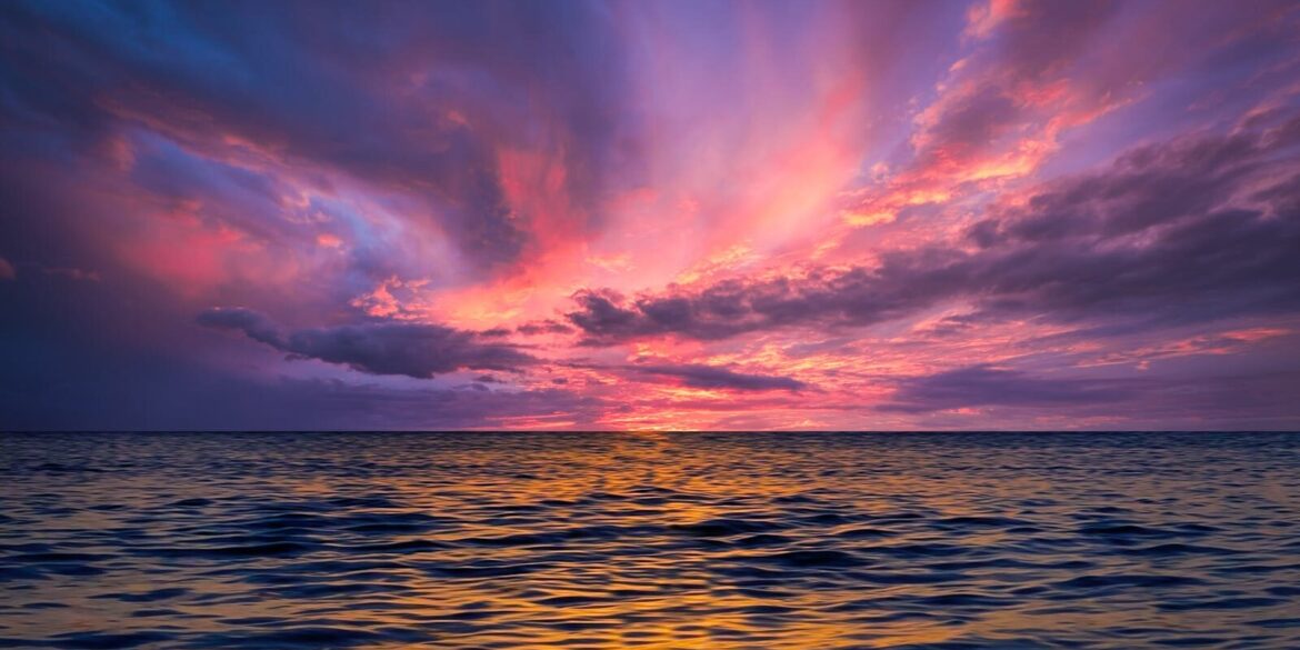 Stunning ocean view at sunset with colorful sky reflecting on the water.